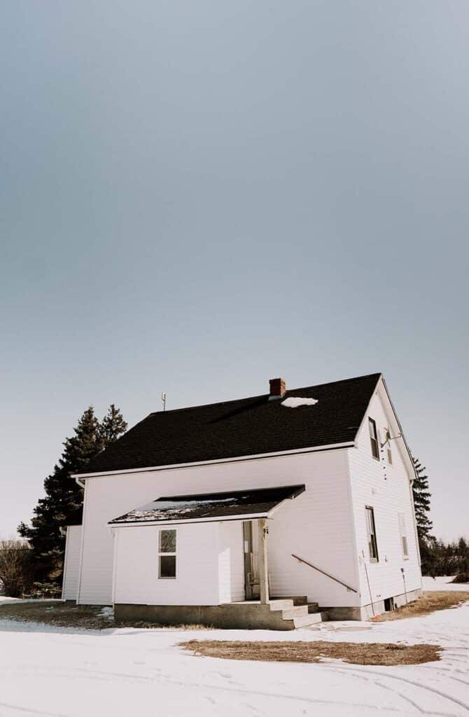Grandma’s House, the restored homestead, standing in long grass under a prairie sky