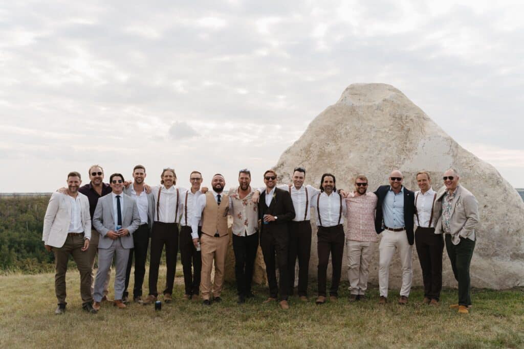 The groomsmen lined up in front of Big Rock, the quarry lookout at Blue Sky Ranch