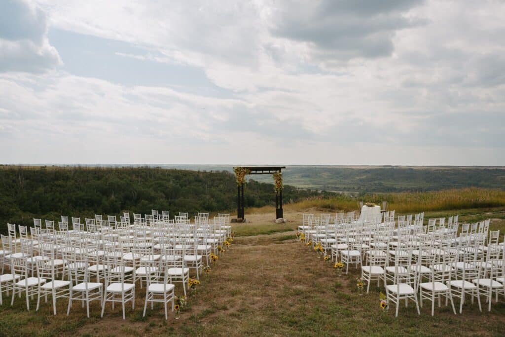 A golden retriever walks the aisle at an outdoor wedding ceremony, Blue Sky Ranch wedding