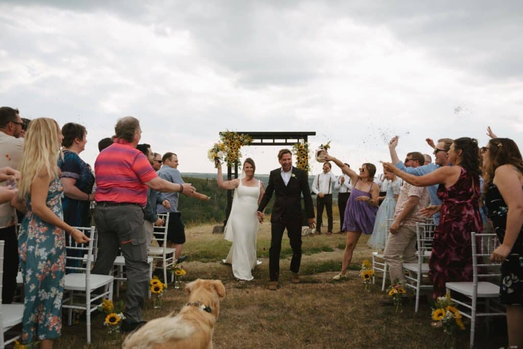 The couple walk back down the aisle as guests cheer, Blue Sky Ranch wedding