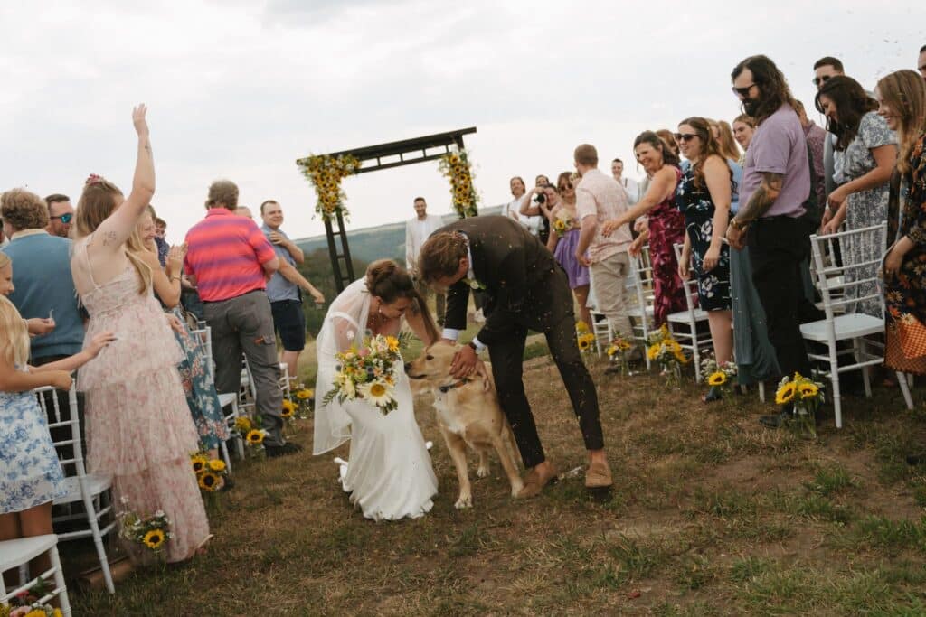 A wedding ceremony on the prairie at Blue Sky Ranch, guests seated in front of a timber arbour